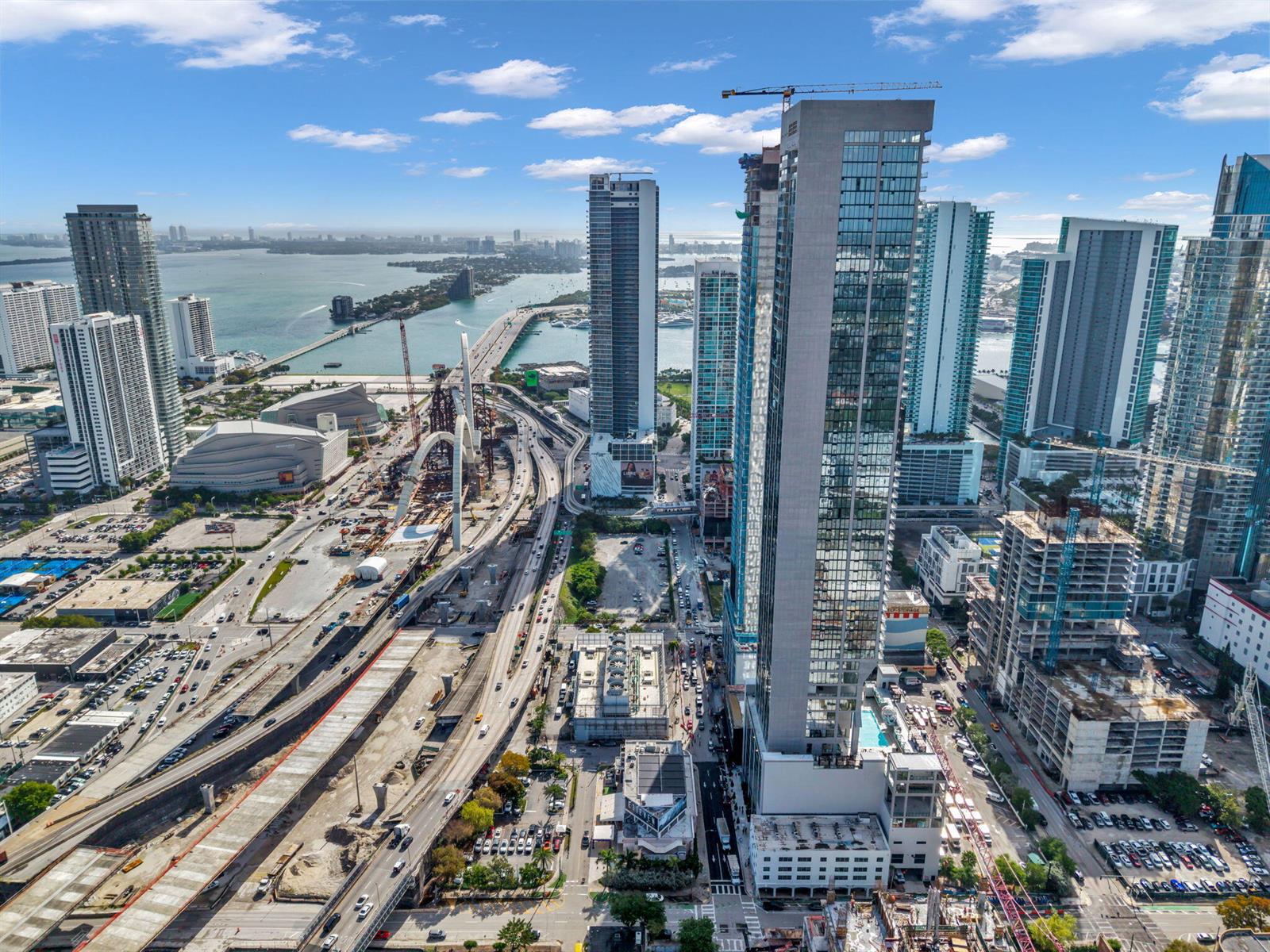 An aerial view of the Miami skyline featuring high-rise buildings, construction sites, and a bridge — 20 NE 11th Street # 3205, Miami FL 33132, MIAMI, FL