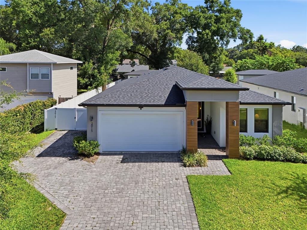 A single-story house with a white garage, wood-look pillars, and a paved driveway — 2015 E KALEY AVENUE, ORLANDO, FL