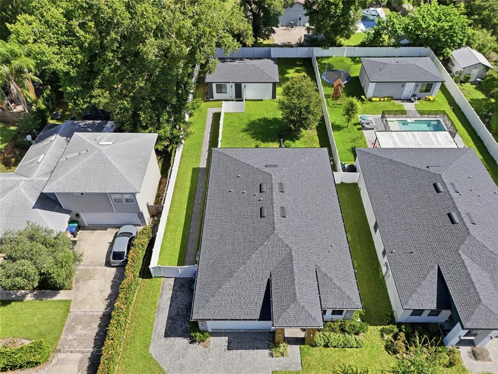 An aerial view shows three residential houses with gray roofs and fenced backyards — 2015 E KALEY AVENUE, ORLANDO, FL
