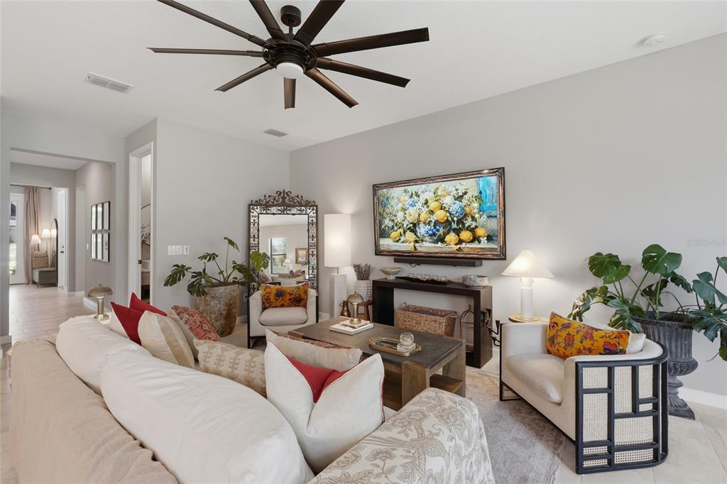 A living room features a large ceiling fan, a sofa, two armchairs, and wall art — 2015 E KALEY AVENUE, ORLANDO, FL