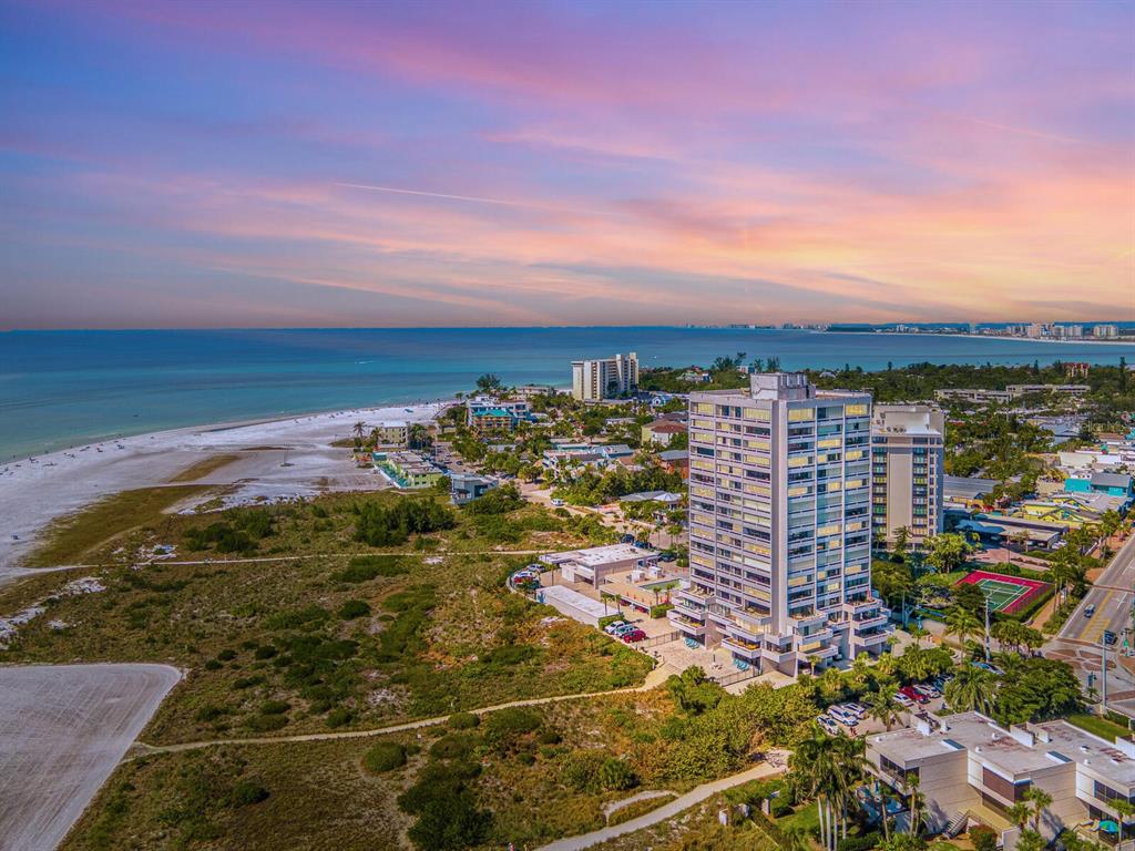 An aerial view of a coastal high-rise building surrounded by beach, vegetation, and other structures — 5400 OCEAN BOULEVARD UNIT 5-3, SARASOTA, FL