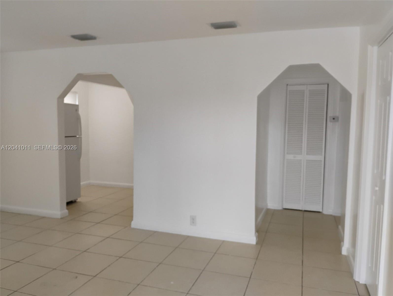An interior view shows a tiled room with two arched doorways leading to other spaces — 2325 Madison St # 1, Hollywood FL 33020, HOLLYWOOD, FL