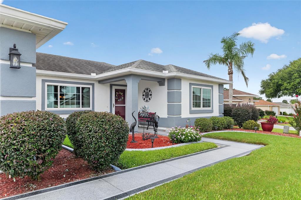 A single-story house with a grey and white exterior, a front porch, and landscaped yard — 13600 SE 87TH CIRCLE, SUMMERFIELD, FL
