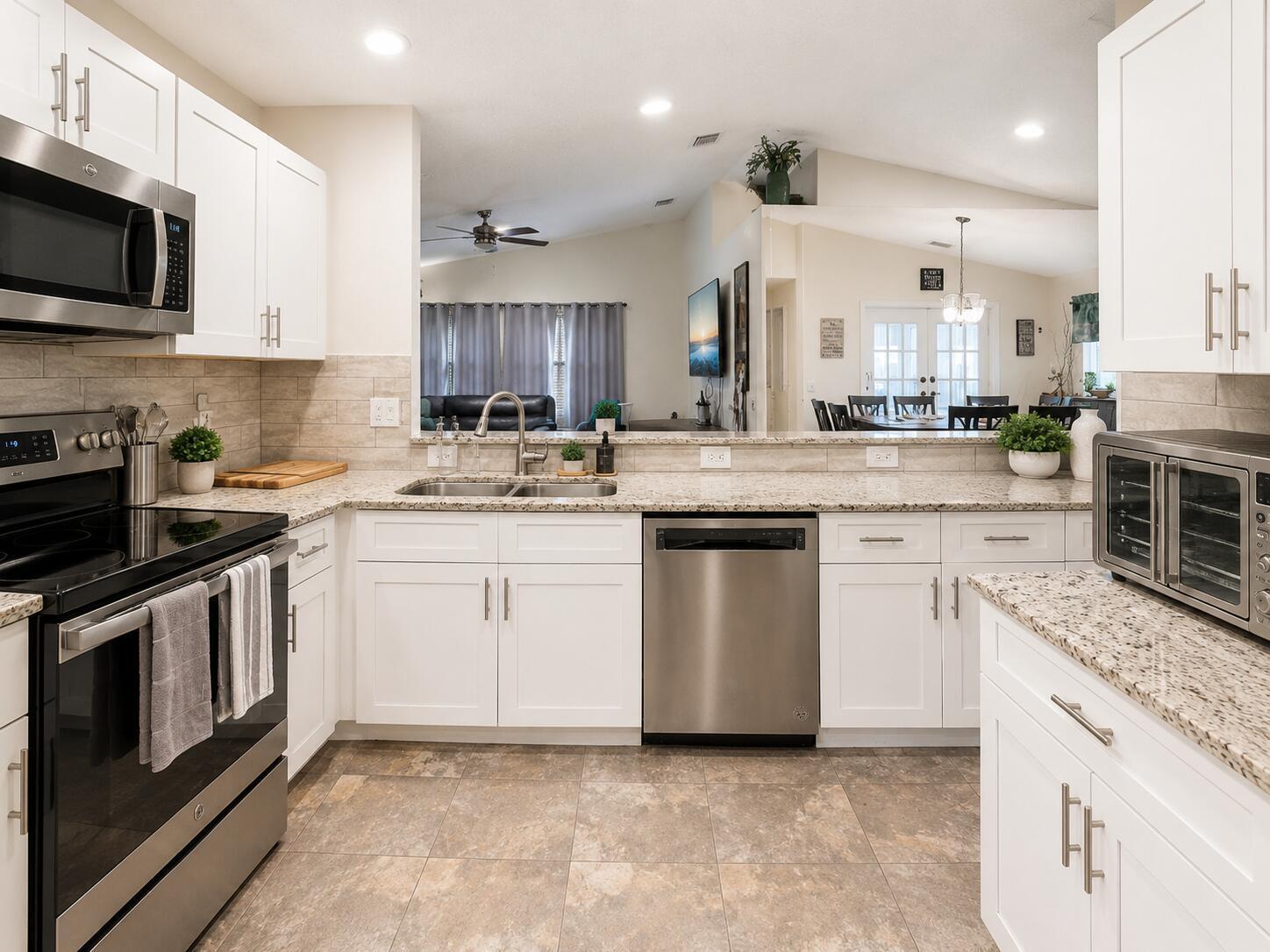 A kitchen with white cabinets, granite countertops, stainless steel appliances, and tile flooring — 7063 Middlebury Drive, Boynton Beach FL 33436, BOYNTON BEACH, FL