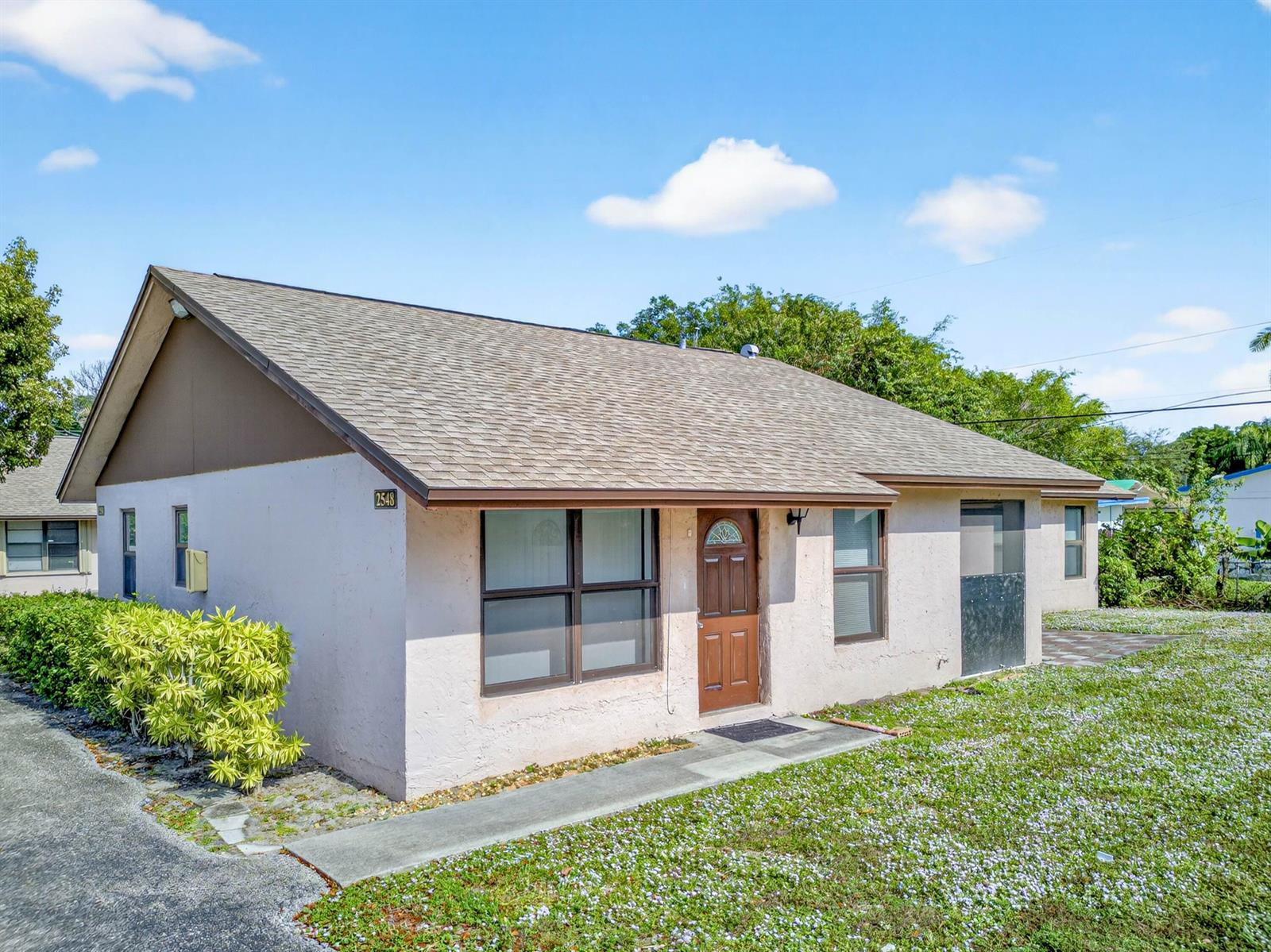 A single-story house with a light-colored stucco exterior, brown roof, and a front entrance — 2548 Ida Way, West Palm Beach FL 33415, WEST PALM BEACH, FL