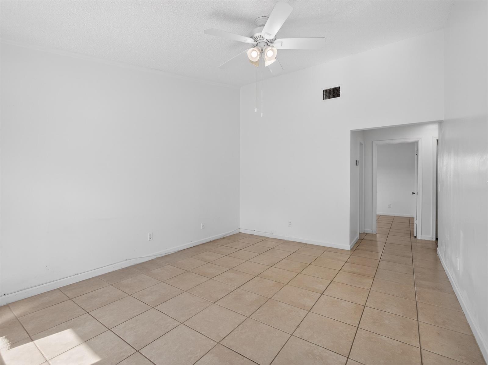 An empty room with white walls, a ceiling fan, and light-colored square floor tiles — 2548 Ida Way, West Palm Beach FL 33415, WEST PALM BEACH, FL