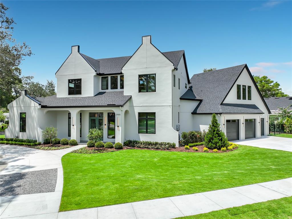 A two-story white house with a dark roof and a three-car garage — 2905 PARKLAND DRIVE, WINTER PARK, FL