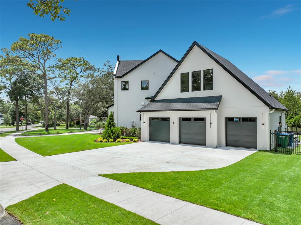 A white two-story house with a three-car garage and a concrete driveway — 2905 PARKLAND DRIVE, WINTER PARK, FL