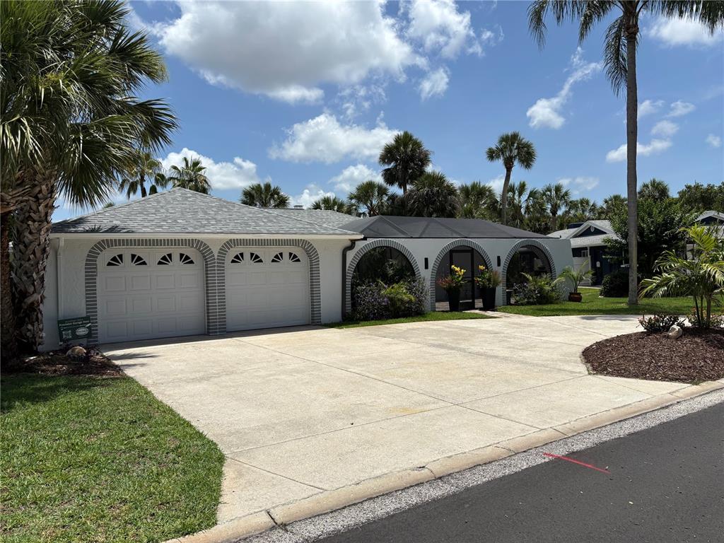 A white house with a two-car garage and a screened-in arched entryway — 5514 GRIDLEY LANE, NEW PORT RICHEY, FL