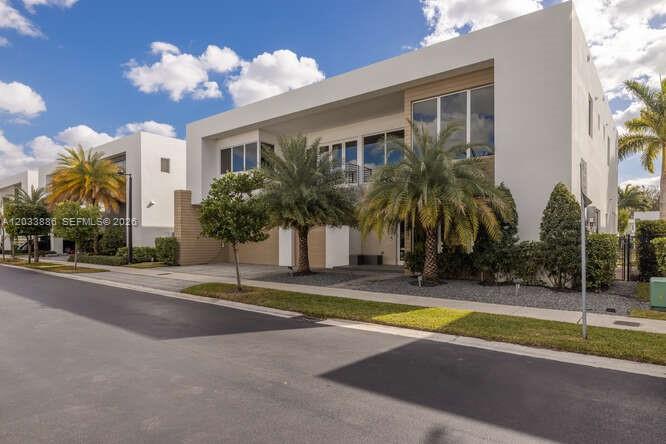 A modern two-story white house with palm trees and a paved driveway under a blue sky — 10250 NW 75th Ter, Doral FL 33178, DORAL, FL