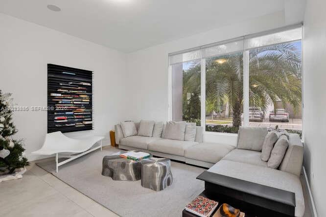 A modern living room features a large sectional sofa, two metallic tables, and a wall-mounted bookshelf — 10250 NW 75th Ter, Doral FL 33178, DORAL, FL
