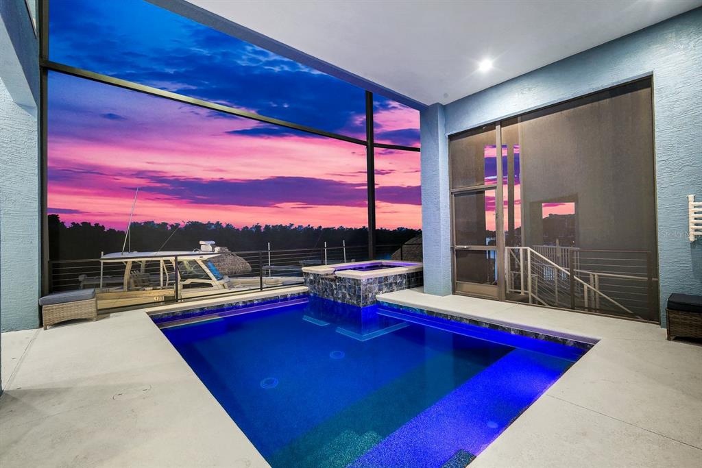 A multi-story blue and yellow coastal home with two garages and a concrete driveway — 5826 SHELL COVE DRIVE, CAPE CORAL, FL