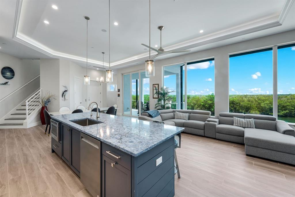 A covered patio features a small swimming pool and hot tub overlooking a sunset waterfront — 5826 SHELL COVE DRIVE, CAPE CORAL, FL