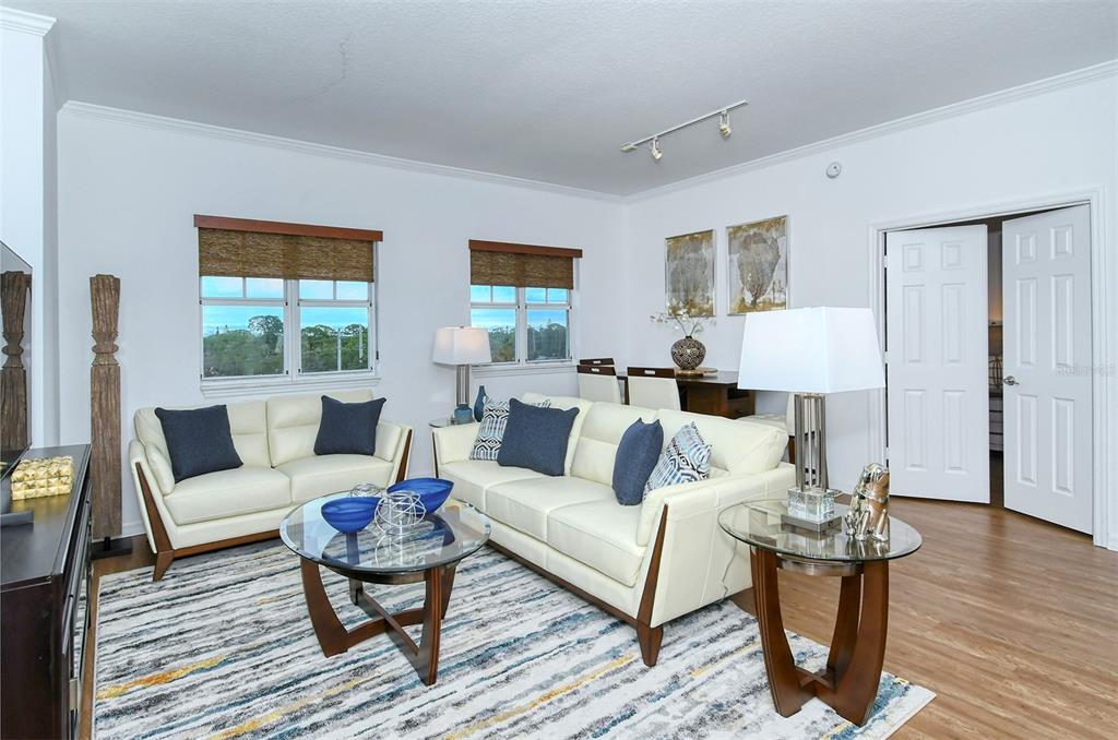 A living room features white leather sofas, a glass coffee table, and a patterned area rug — 1064 N TAMIAMI TRAIL UNIT 1627, SARASOTA, FL