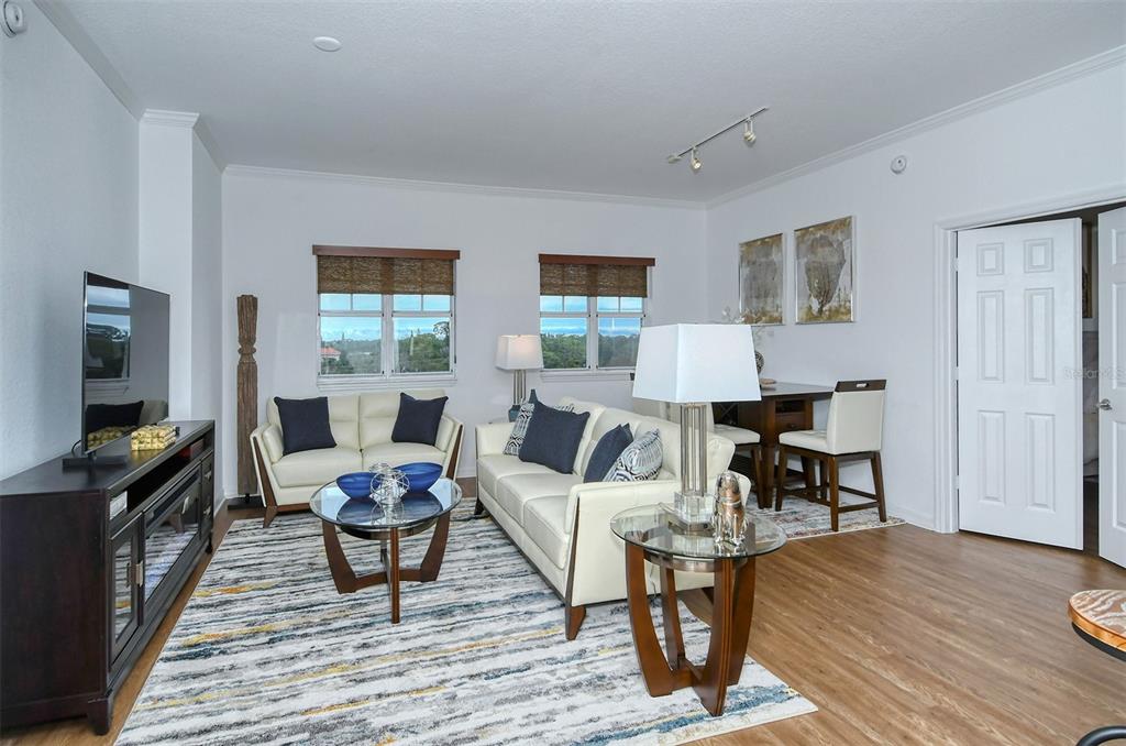 A living room features white sofas, a glass coffee table, and a dining area — 1064 N TAMIAMI TRAIL UNIT 1627, SARASOTA, FL