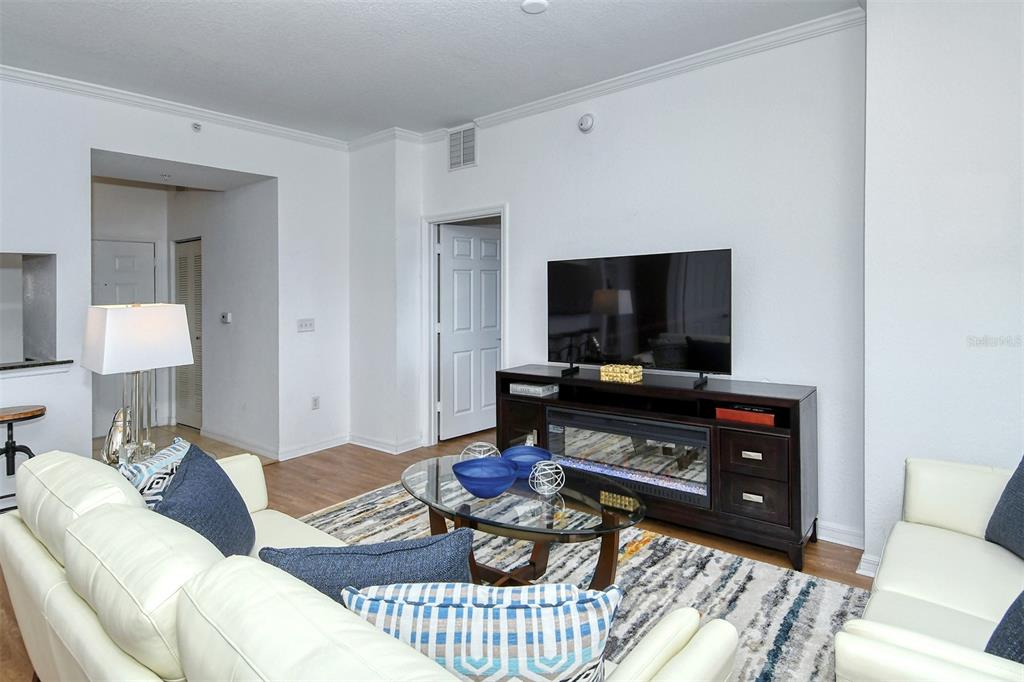 A living room features a white sofa, a glass coffee table, and a television stand — 1064 N TAMIAMI TRAIL UNIT 1627, SARASOTA, FL