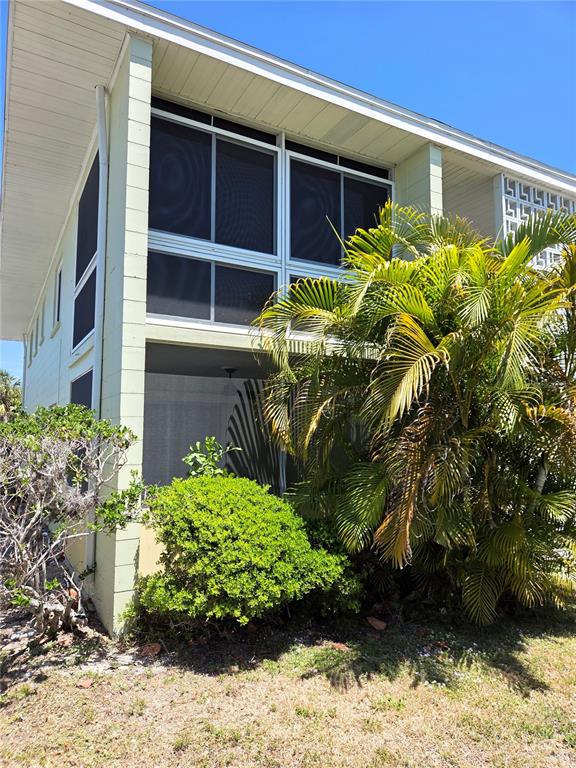 A two-story building exterior features screened-in porches and a large palm tree in the yard — 10215 MANATEE AVENUE W UNIT 1, BRADENTON, FL