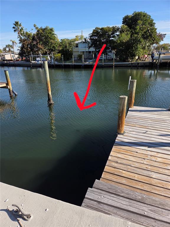 A view of a canal from a wooden boat dock with several pilings — 10215 MANATEE AVENUE W UNIT 1, BRADENTON, FL