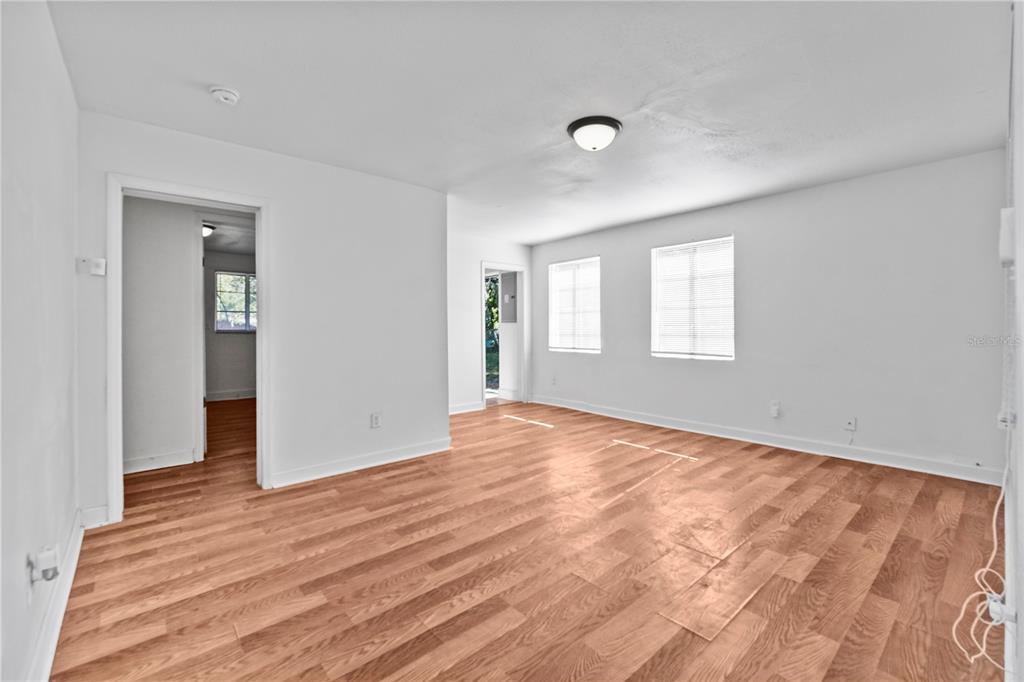 An empty room with white walls, light wood flooring, and two windows with white blinds — 1730 N ORANGE STREET, MOUNT DORA, FL