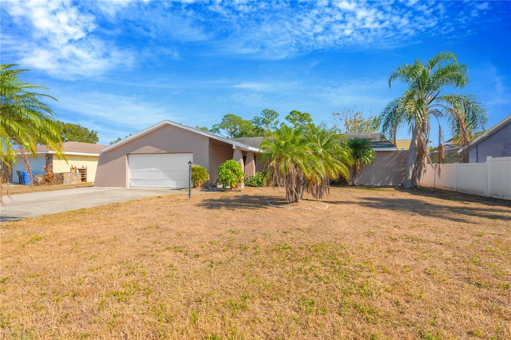 A single-story house with a white garage door and palm trees in the front yard — 6507 MANILA PALM WAY, APOLLO BEACH, FL