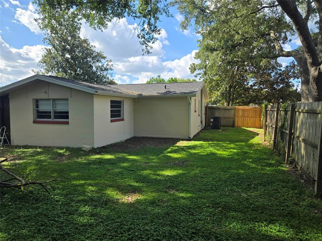 The exterior of a beige house with a grassy backyard and a wooden fence — 3762 SW 147TH STREET, OCALA, FL
