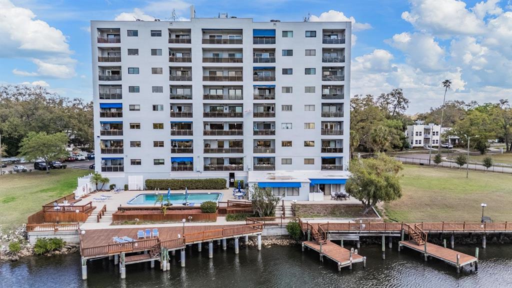 An aerial view of a multi-story apartment building with a pool and wooden docks — 2780 N RIVERSIDE DRIVE UNIT 105, TAMPA, FL