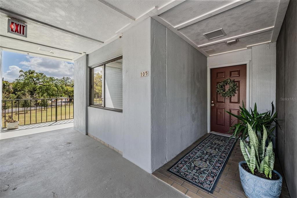 An exterior view of a building entrance with a brown door, a window, and plants — 2780 N RIVERSIDE DRIVE UNIT 105, TAMPA, FL