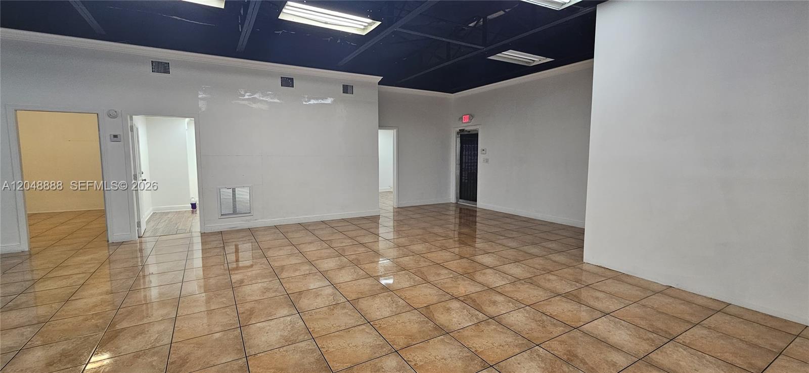 An empty commercial space features white walls, a black ceiling, and brown tiled flooring — 2223 NW 26th Ave, Miami FL 33142, MIAMI, FL