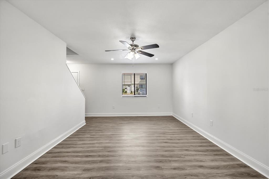 An empty room with light gray walls, wood-look flooring, a ceiling fan, and a window — 217 DEBORA COURT, ALTAMONTE SPRINGS, FL