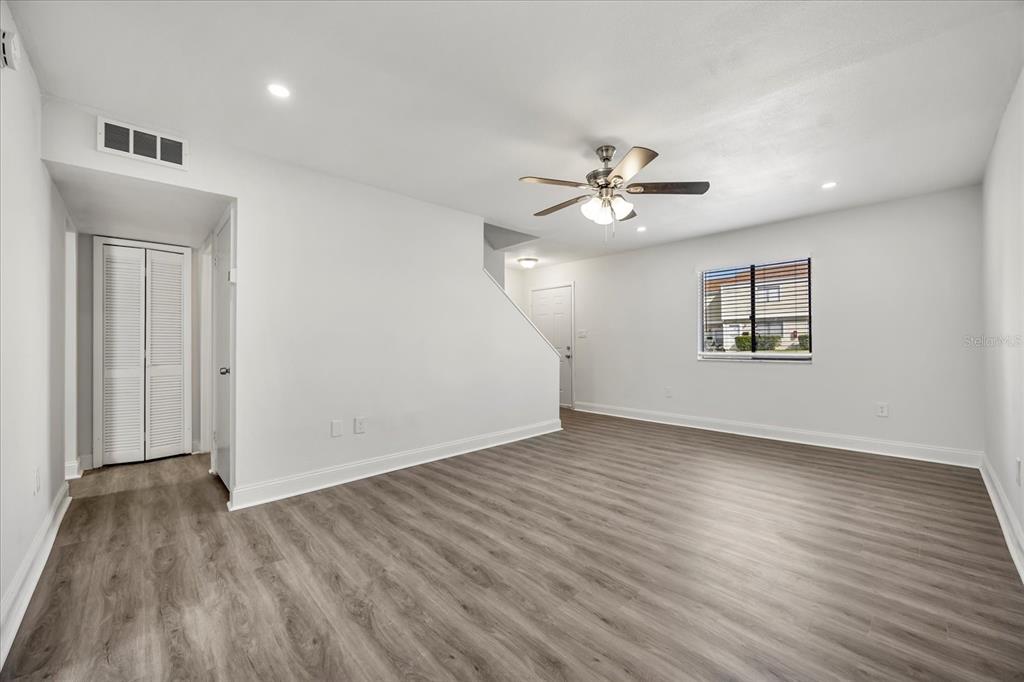 An empty living room features light gray walls, wood-look flooring, and a ceiling fan — 217 DEBORA COURT, ALTAMONTE SPRINGS, FL