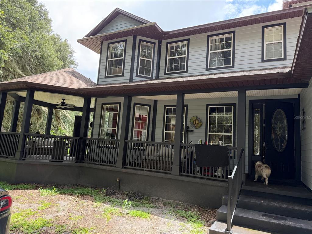 A two-story house with light blue siding, a dark porch, and a wrap-around gazebo area — 18900 LAKEVIEW DRIVE, CLERMONT, FL