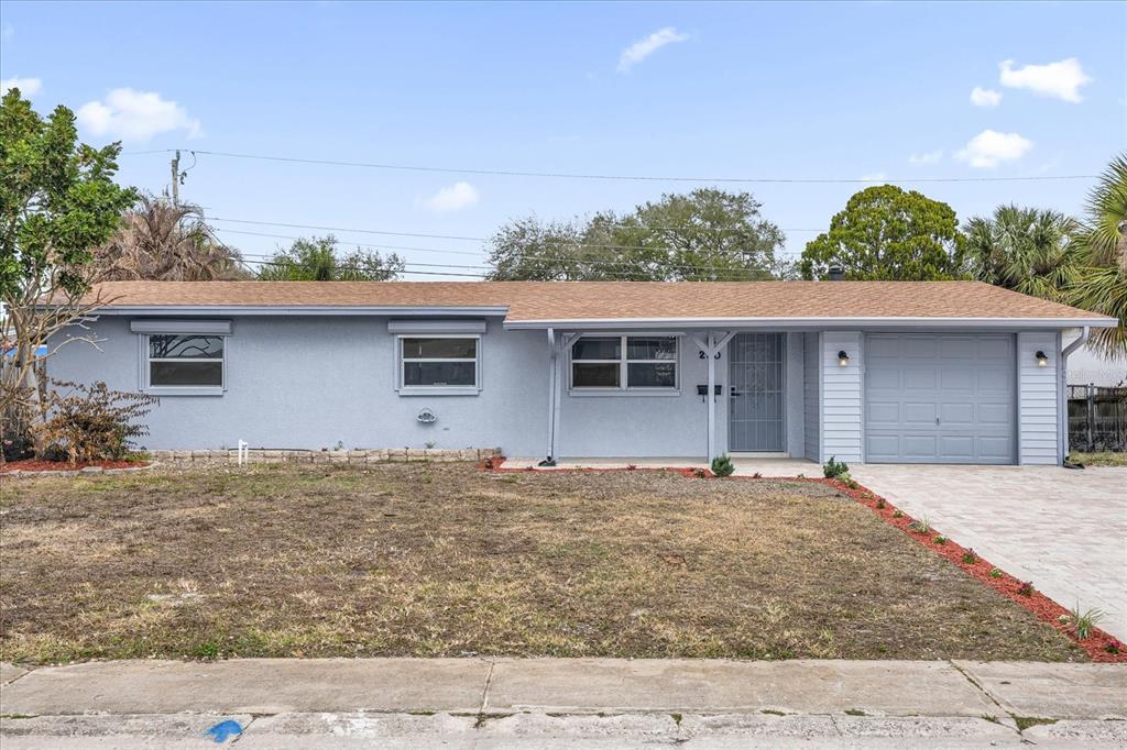 A single-story house with a light blue exterior, a brown roof, and an attached garage — 290 PATRICK AVENUE, MERRITT ISLAND, FL