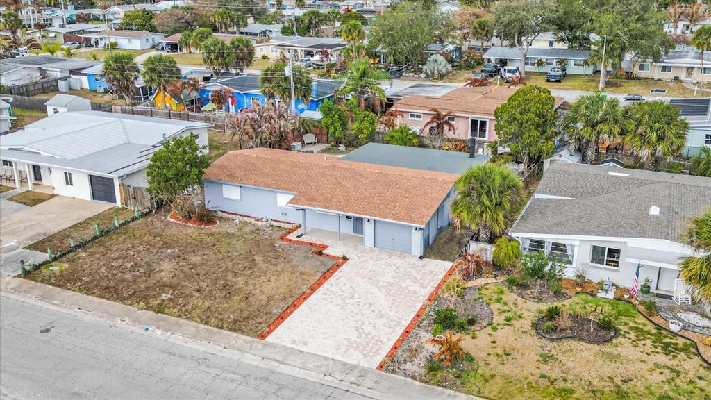 An aerial view of a light blue house with a brown roof and paved driveway — 290 PATRICK AVENUE, MERRITT ISLAND, FL