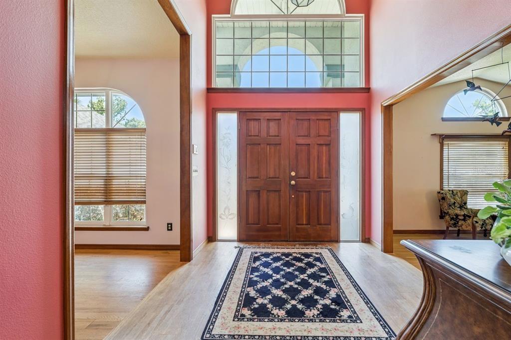 A foyer with wood floors, a double front door, and a large arched transom window — 908 ALMOND TREE CIRCLE, ORLANDO, FL