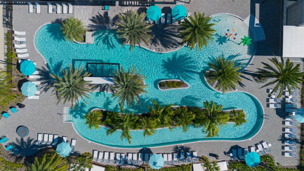An aerial view shows a large, irregularly shaped swimming pool surrounded by lounge chairs and palm trees — 5943 HIGH SEAS DRIVE, ORLANDO, FL