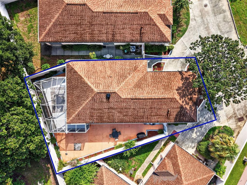 An aerial view shows a house with a brown shingled roof, screened patio, and deck — 1717 FRANCISCO STREET, THE VILLAGES, FL