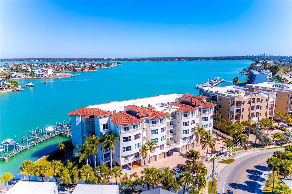 An aerial view of a multi-story waterfront apartment complex with a red tile roof — 220 108TH AVENUE UNIT 304, TREASURE ISLAND, FL
