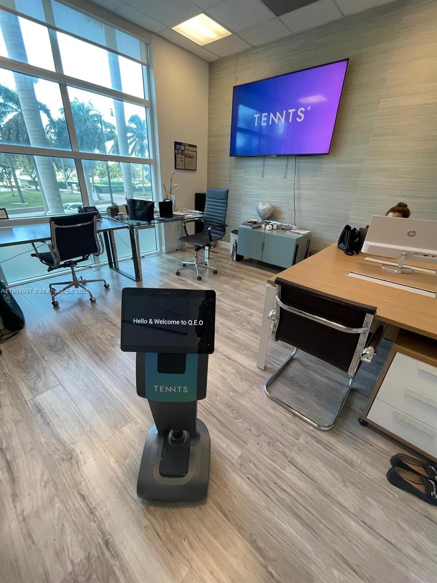 An office space features a robotic kiosk, desks, chairs, and a large wall-mounted television screen — 1900 N Bayshore Dr # 1A, Miami FL 33132, MIAMI, FL