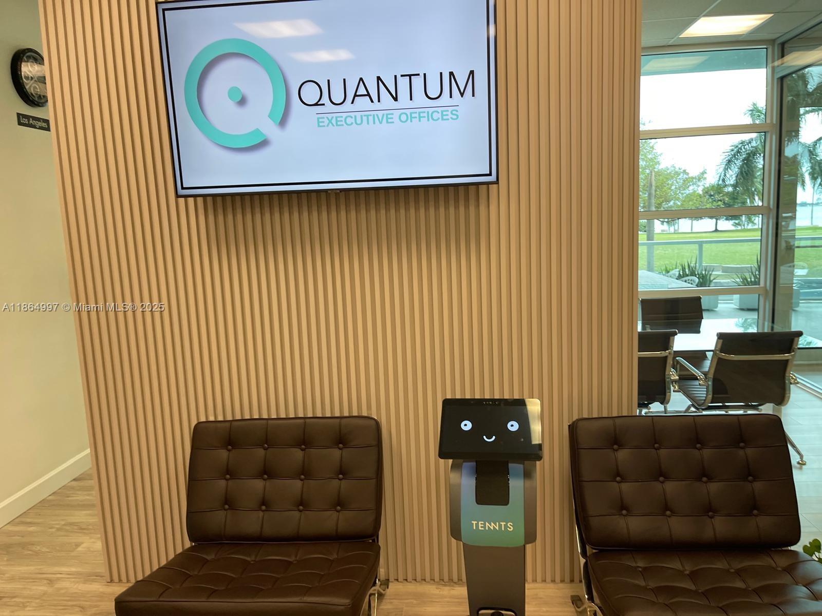 A reception area features a digital sign, slatted wall paneling, two leather chairs, and a robot — 1900 N Bayshore Dr # 1A, Miami FL 33132, MIAMI, FL