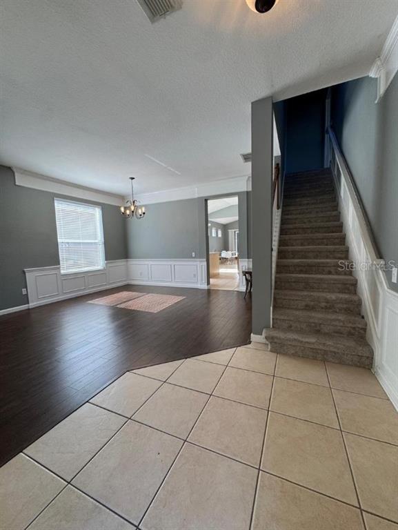 An entryway with tile flooring leads to a living room featuring dark wood-look floors — 8526 GREENBANK BOULEVARD, WINDERMERE, FL