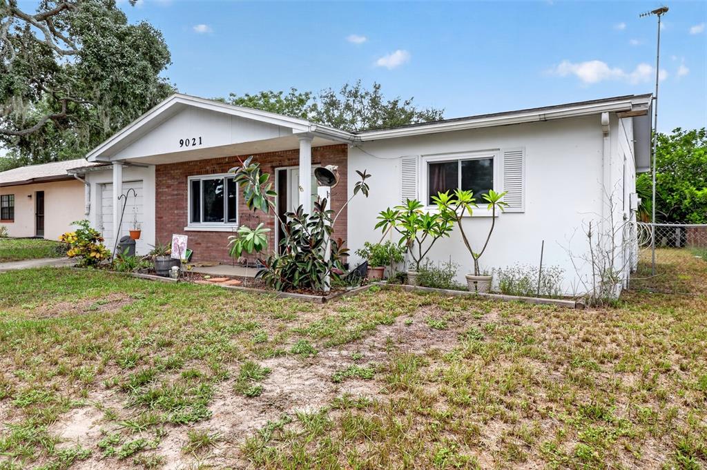 A single-story house with a brick facade, white siding, and a covered front porch — 9021 RICHWOOD LANE, PORT RICHEY, FL