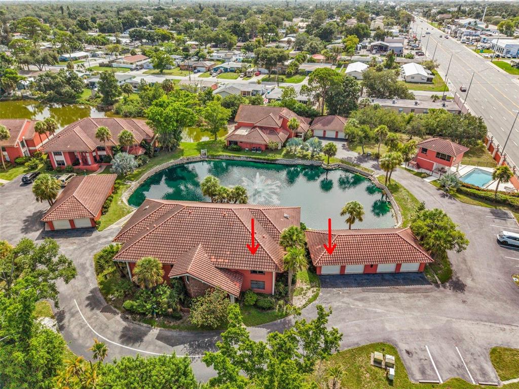 An aerial view shows a red-roofed building and a detached garage beside a pond — 3013 CLARK ROAD UNIT 6, SARASOTA, FL