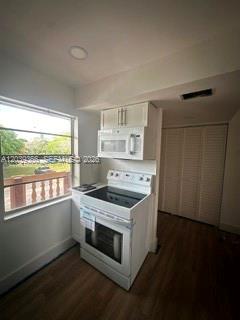 A kitchen features a white electric stove, an over-the-range microwave, and a window view — 9272 SW 3rd St # 413, Boca Raton FL 33428, BOCA RATON, FL
