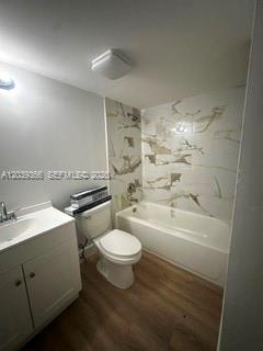 A bathroom features a white vanity, a toilet, and a bathtub with marble-patterned wall tiles — 9272 SW 3rd St # 413, Boca Raton FL 33428, BOCA RATON, FL