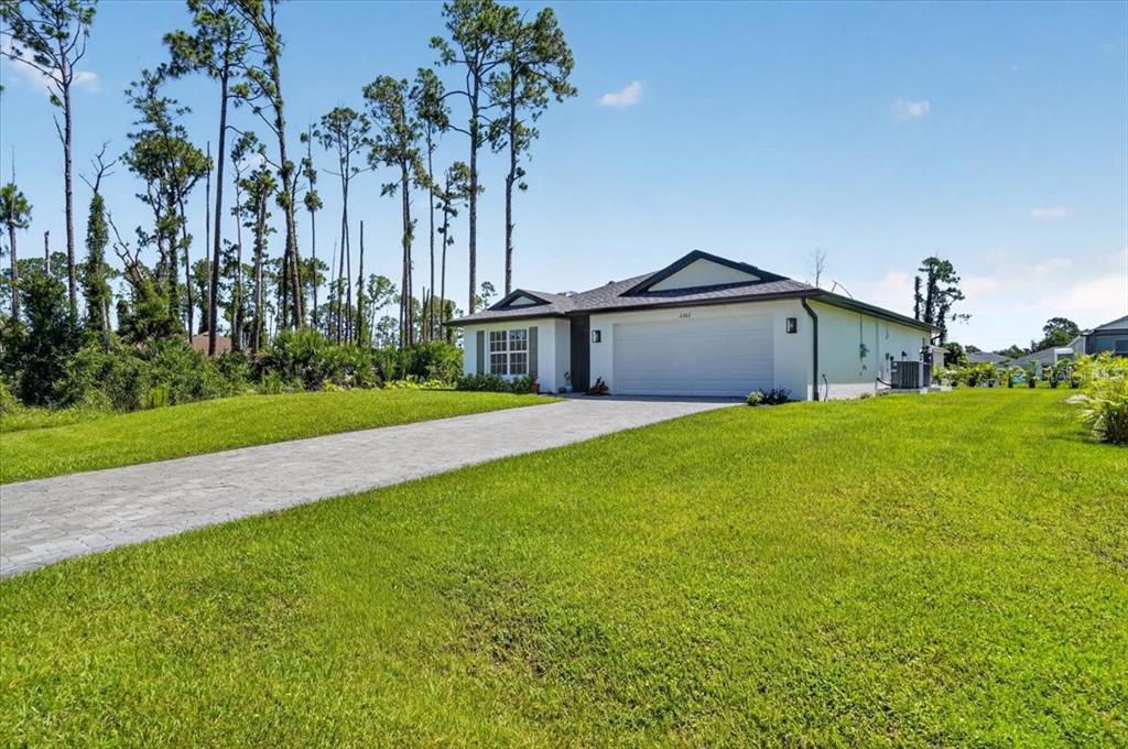 A single-story house with a white exterior, a two-car garage, and a paved driveway — 2362 HAGOPLAN LANE, NORTH PORT, FL