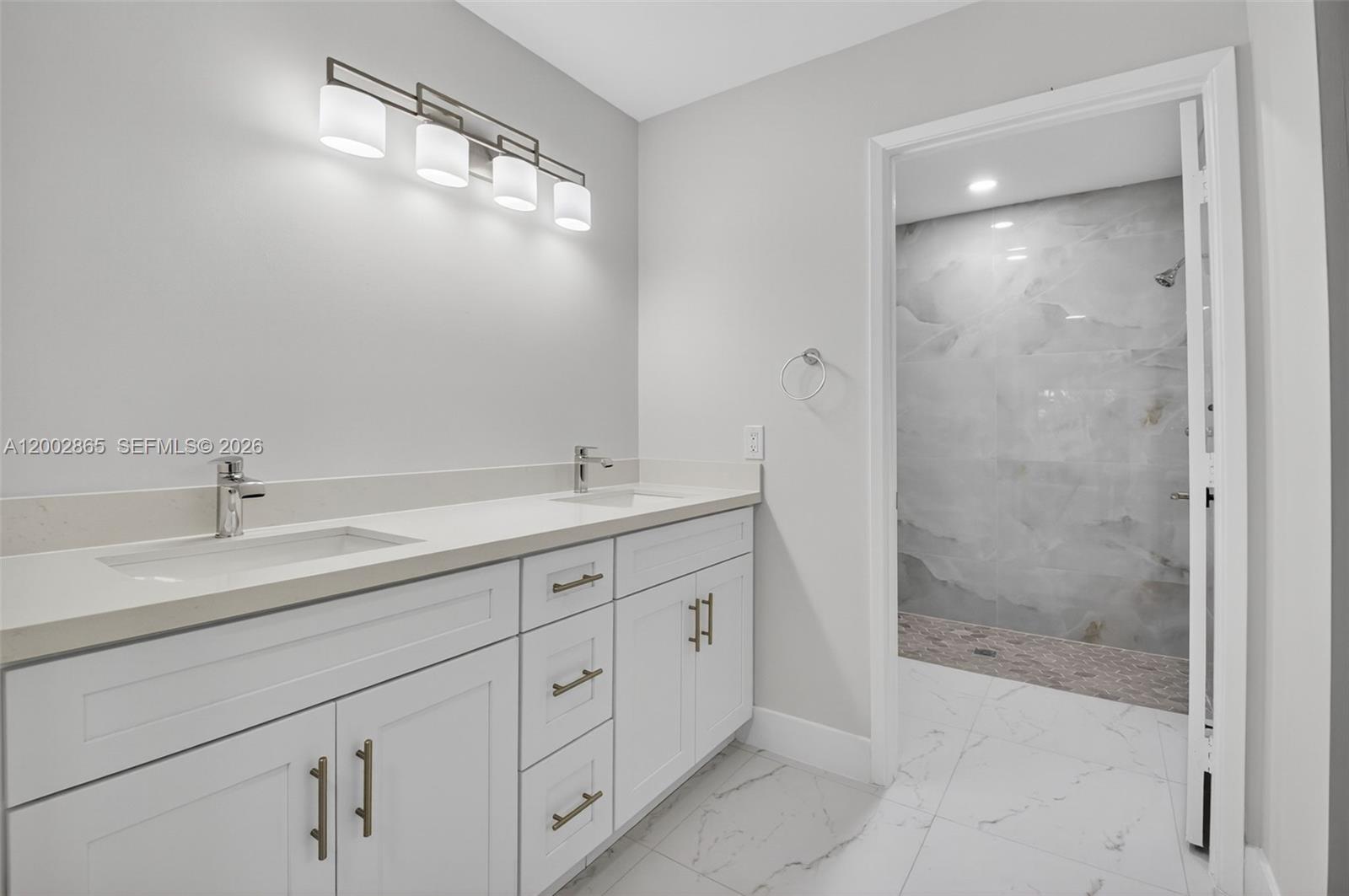 A modern bathroom features a double vanity with white cabinets and a walk-in shower — 8067 Summerbreeze Ln, Boca Raton FL 33496, BOCA RATON, FL