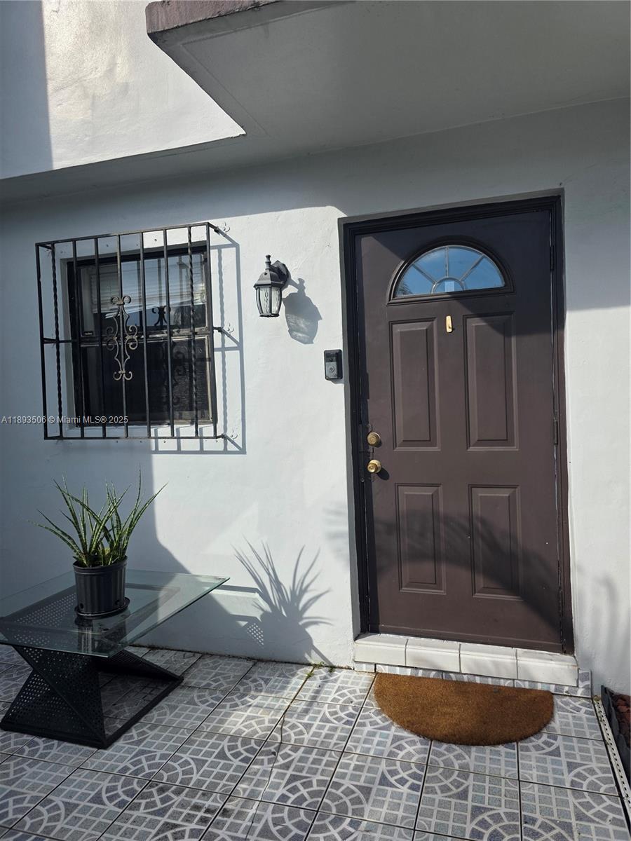 A brown front door with a window sits beside a window with security bars — 8000 SW 152nd Ave # 115, Miami FL 33193, MIAMI, FL