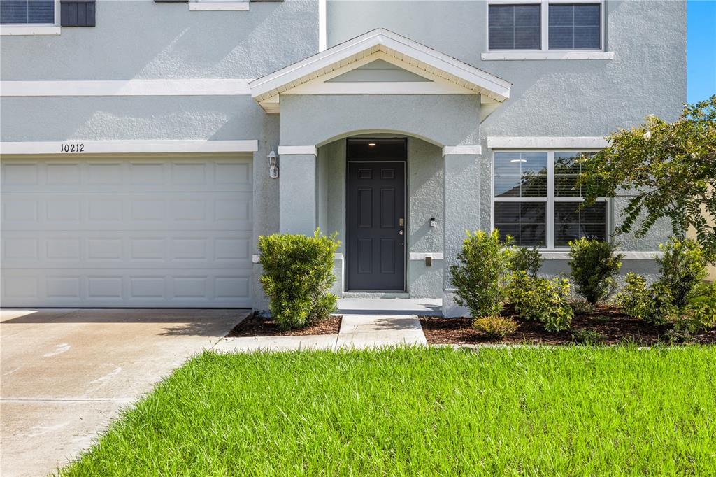 The exterior of a two-story house features a garage, a front entrance, and landscaping — 10212 GOLDEN LIGHT COURT, RIVERVIEW, FL