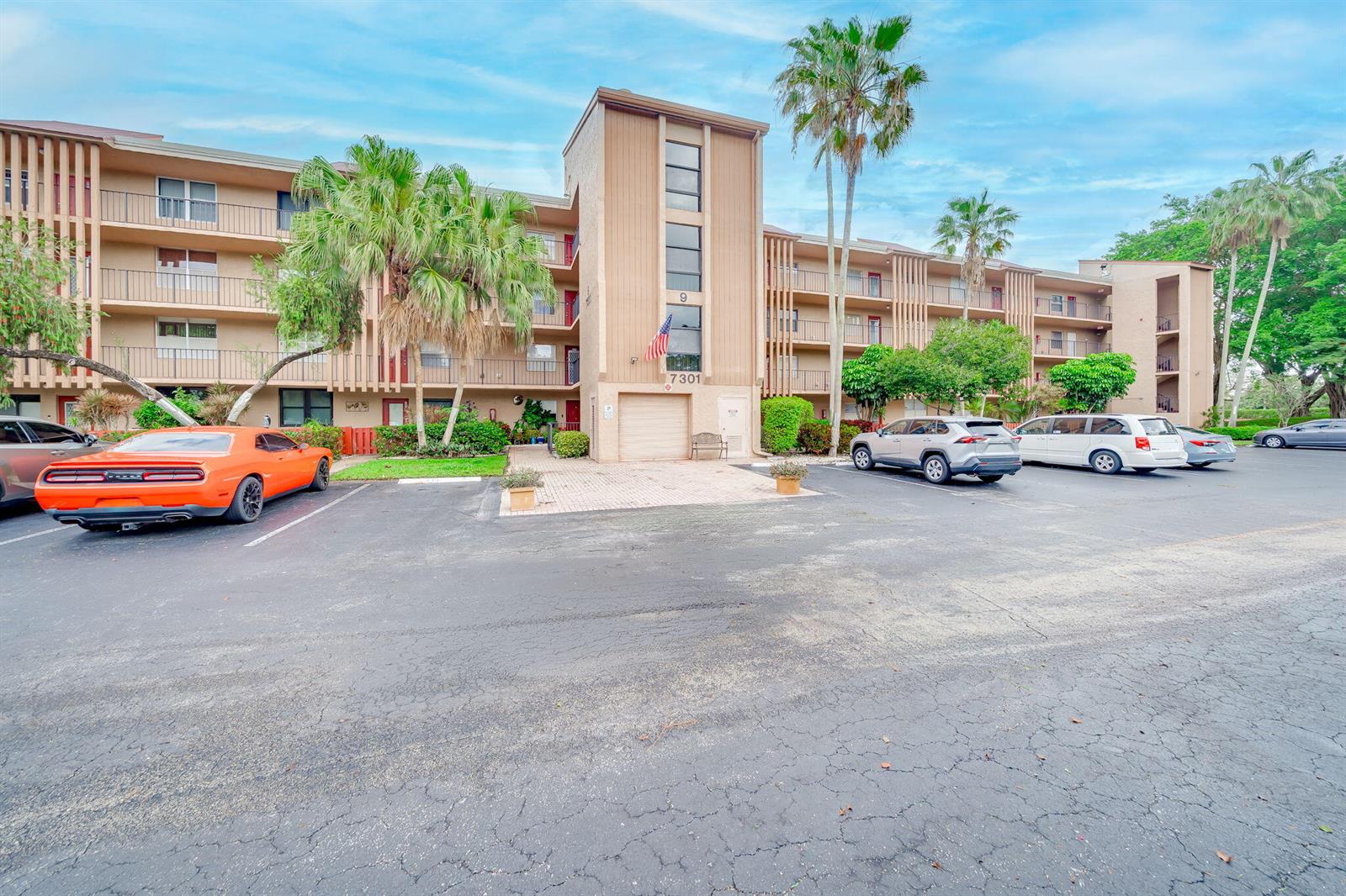A multi-story apartment building with a parking lot and palm trees in front — 7301 NW 1st Street # 402, Margate FL 33063, MARGATE, FL