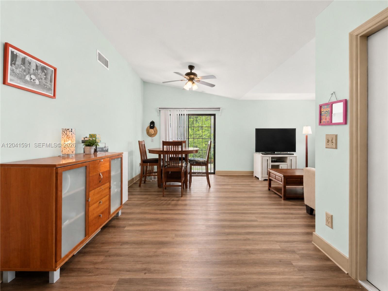 A living and dining area features light green walls, wood-look flooring, and a ceiling fan — 13341 SW 114th Pl, Miami FL 33176, MIAMI, FL